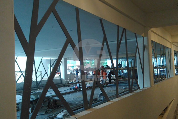 Installation progress of the FRP Feature Wall at The Sentral Residences car park with construction activities in the background.