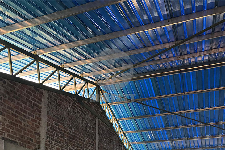 Interior view of a chicken farm with FRP roofing, allowing natural light